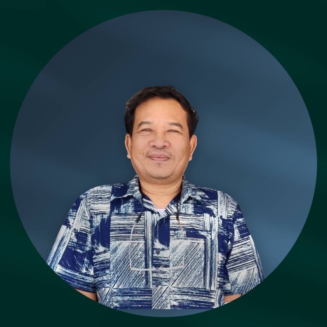 Person wearing a blue and white patterned shirt in front of a blue background with a circular frame.