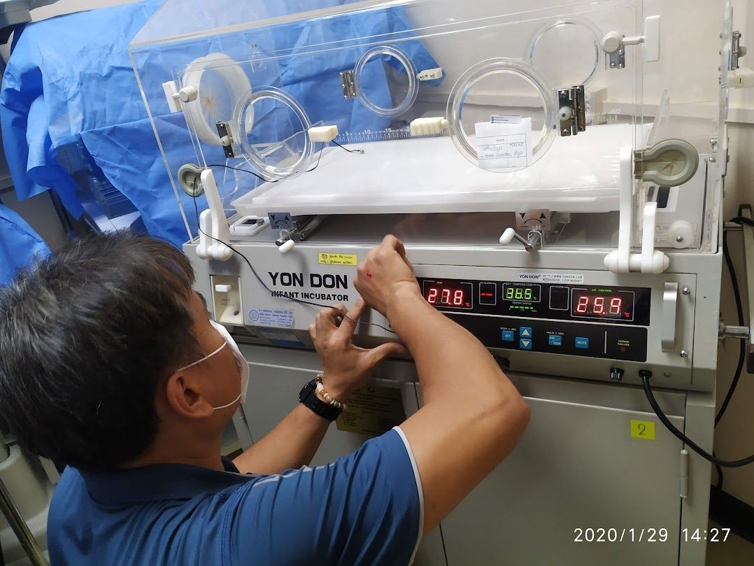 Person adjusting the settings on a Yon Don infant incubator in a medical facility.